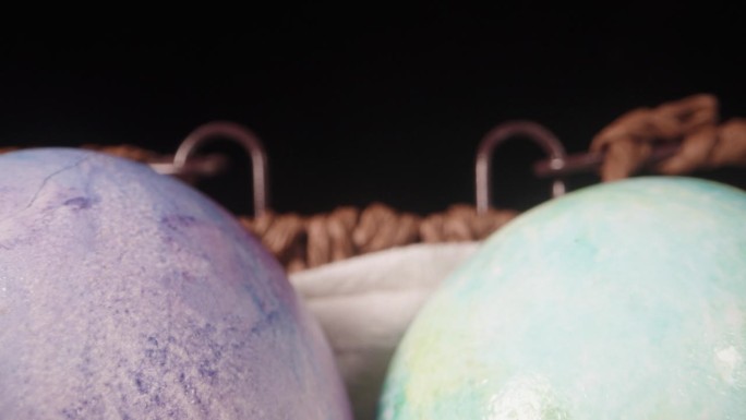 一个柳条篮子，里面有色彩鲜艳的复活节彩蛋。黑色背景。多莉滑块极端特写。