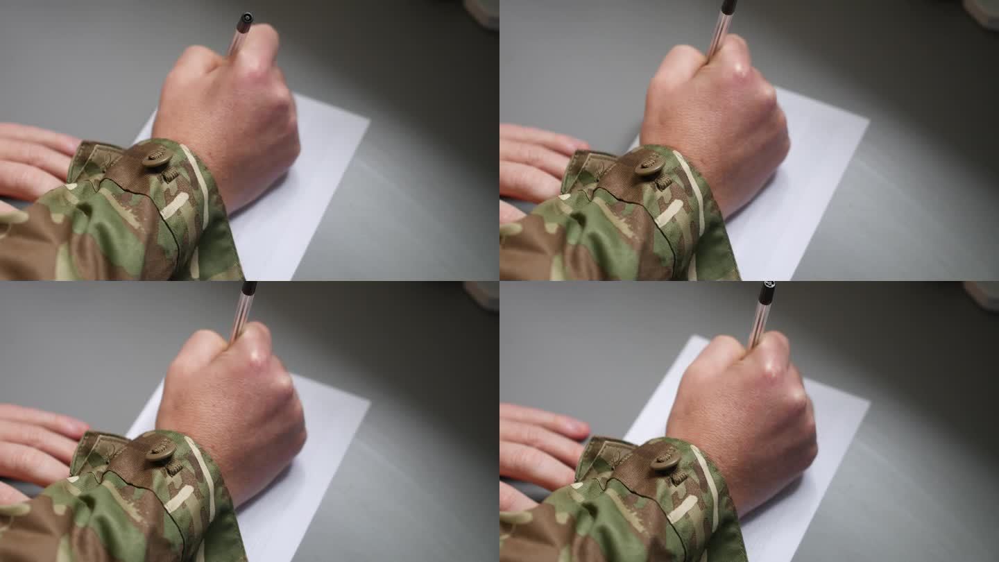 一个陆战队员用一支笔在一张纸上写信
