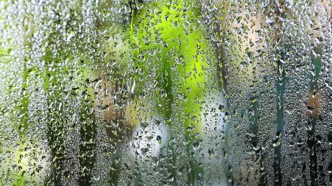 雾蒙蒙的玻璃带着水汽、雾气、流动。窗户上有水滴深色背景上的雨滴