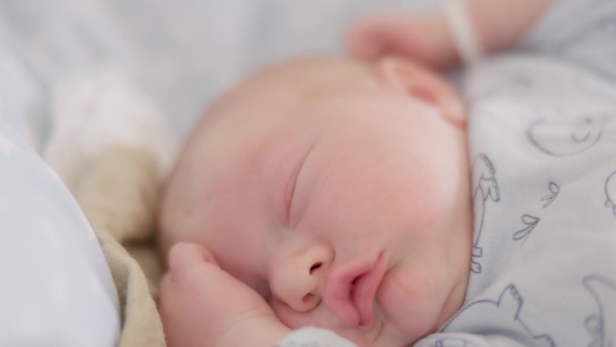 可爱的新生男婴在医院产房睡觉时伸展身体的特写镜头