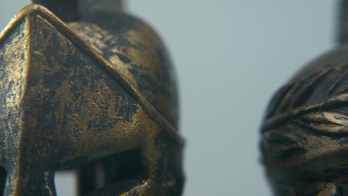 一个斯巴达设计的特写微距细节镜头，两个不同的古代战士金属青铜头盔顶部，发光的纹理形状，工作室照明，4