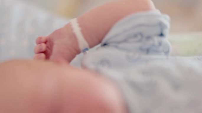 可爱的新生儿在医院产房睡觉时伸展和打哈欠的特写手持镜头。一个5天大的婴儿