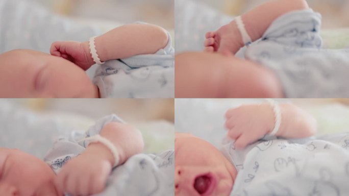 可爱的新生儿在医院产房睡觉时伸展和打哈欠的特写手持镜头。一个5天大的婴儿