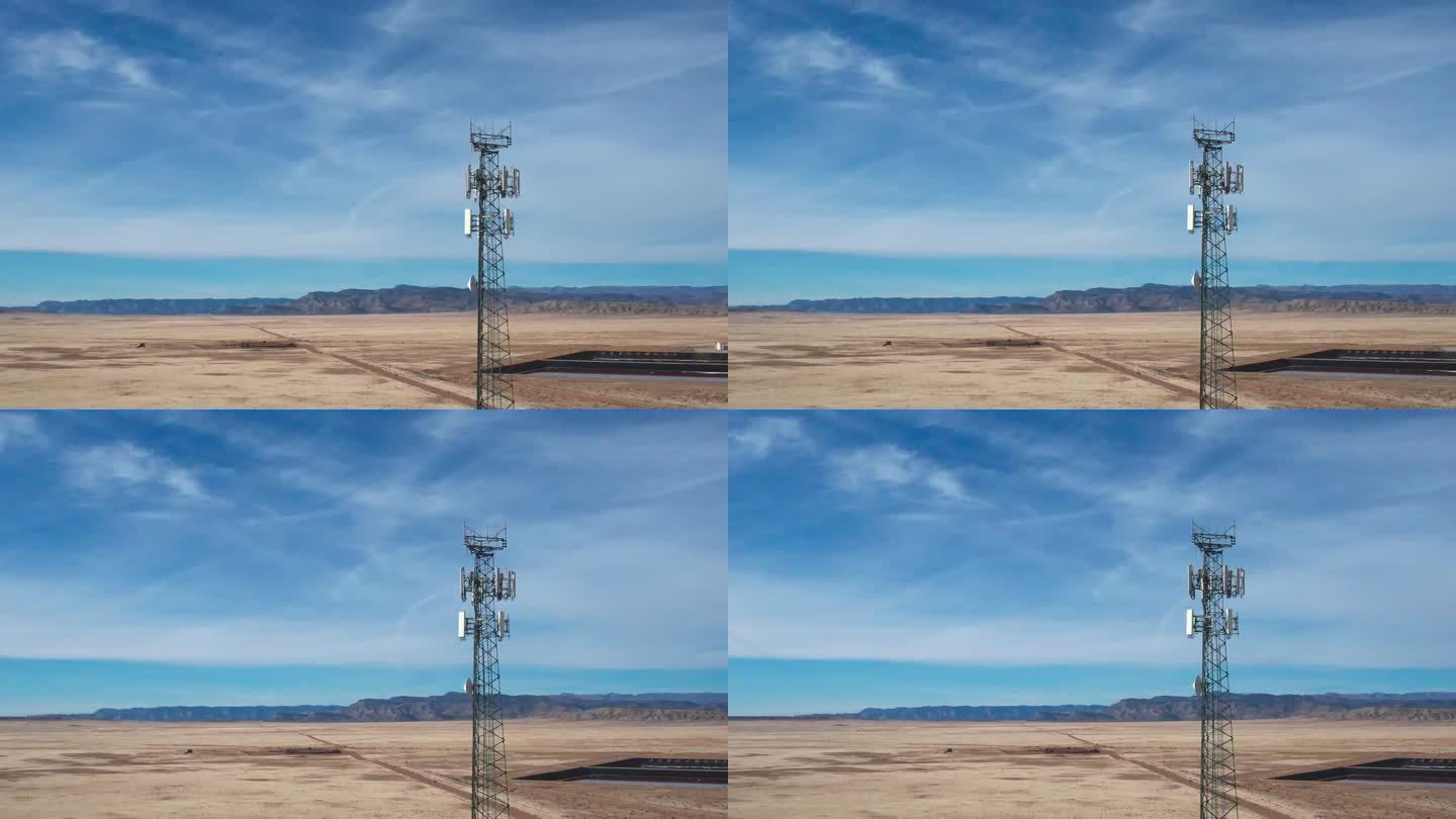 在一个阳光明媚的冬日，犹他州沙漠中一座5G蜂窝塔的无人机照片，天空充满了戏剧性的云层