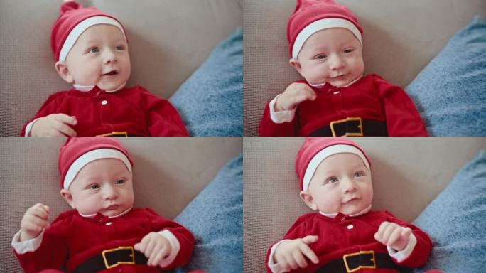 可爱快乐的小男孩穿着圣诞老人的服装坐在家里的沙发上