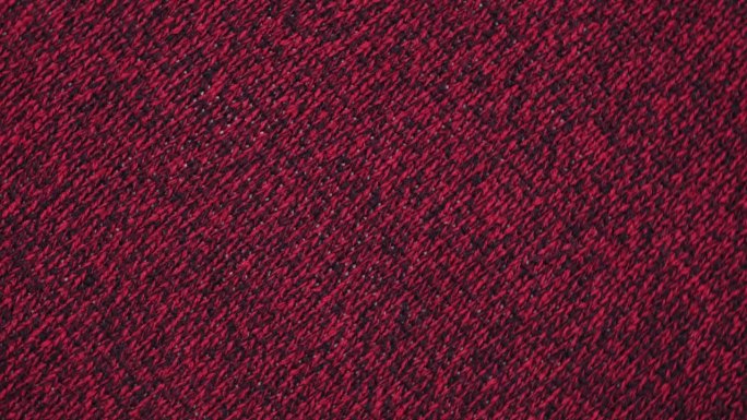 柔软的针织羊毛详细的纹理。天然织物近距离针织图案。品红针织品，温暖的羊绒表面。旋转,宏。舒适的纺织背