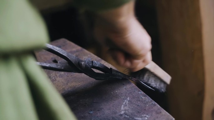铁匠用刷子清理产品的残根和金属屑。他对小费做了最后的修改