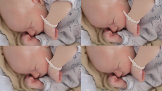 在妇产医院的婴儿床上熟睡的新生男婴的特写镜头