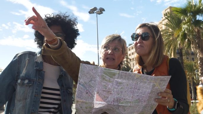 三个不同的中年女性游客在城市度假时看着地图