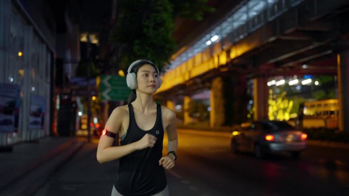 健康女性下班后喜欢夜间街头跑步。