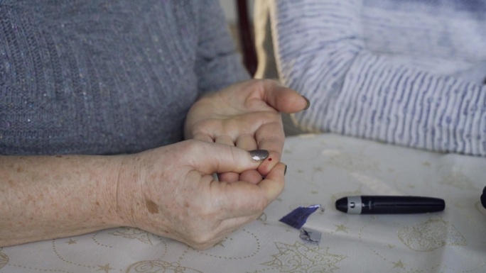 一位妇女采血，用血糖仪检查她的血糖水平。