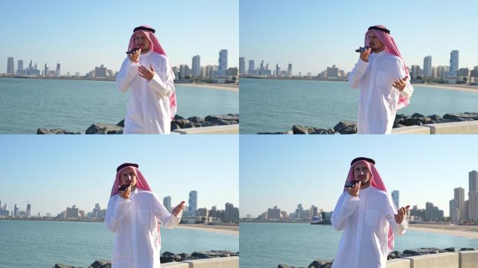 在科威特城的海岸上，一名阿拉伯男子戴着传统的阿拉伯头巾发出语音信息