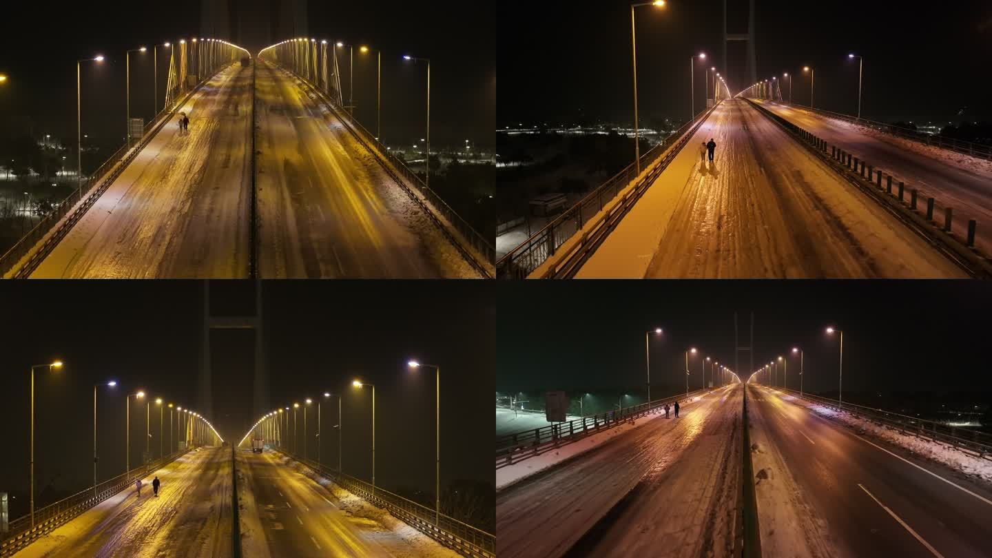 情侣行走在大雪结冰封路的荆州长江大桥夜景
