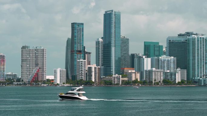 迈阿密布里克尔市中心办公区与豪华游艇航行在佛罗里达州，美国。现代美国大都市的高滨水商业和住宅摩天大楼