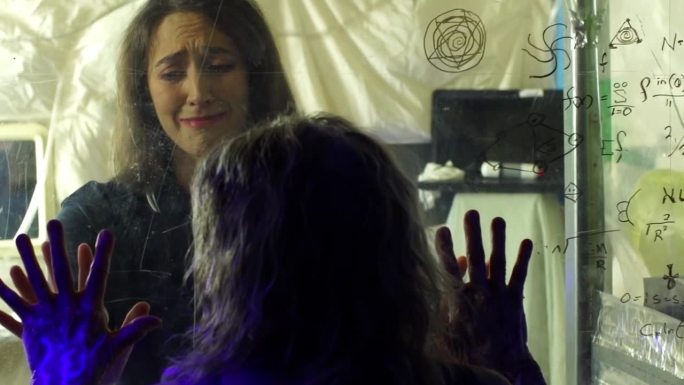 在科幻电影的场景中，小女孩在玻璃后面哭泣，同时看着一个被感染的女人