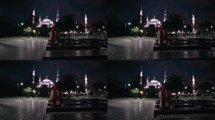 宁静之夜:穆斯林妇女在灯火辉煌的广场上沉思圣索菲亚大教堂的雄伟之美#圣索菲亚之夜#宁静反思#城市之光
