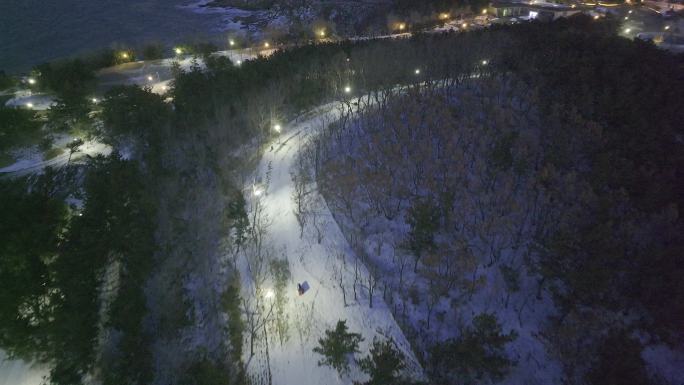 航拍俯瞰威海市环翠区喂海公园雪地路灯夜景