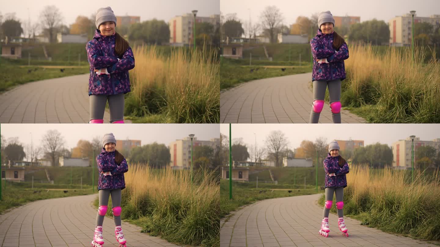 在城市公园的户外，小女孩穿着护膝和护肘站在旱冰鞋上。喜欢运动的孩子