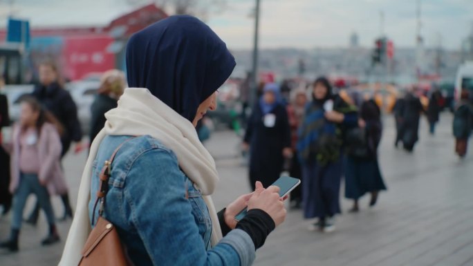 女游客在伊斯坦布尔的某个地方散步时使用她的智能手机