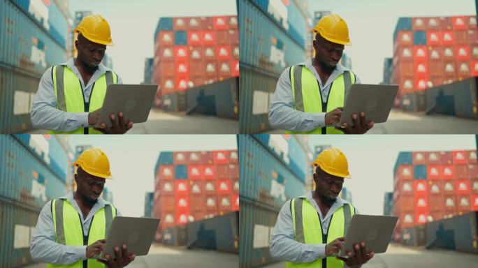 非裔美国黑人工业工程师，头戴黄色安全帽，身穿安全背心，站在集装箱堆场仓库用笔记本电脑检查集装箱。海运