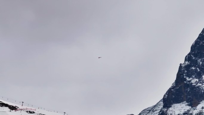 瑞士山地救援直升机在雪上滑雪胜地上空飞行