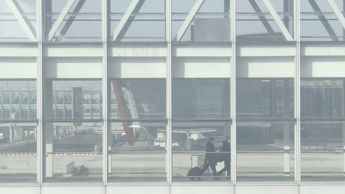 旅客从廊桥下机，波音747飞机从后方经过