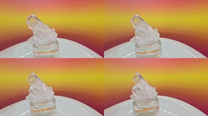 一个石英水晶石在一个模糊的彩色背景旋转的特写镜头