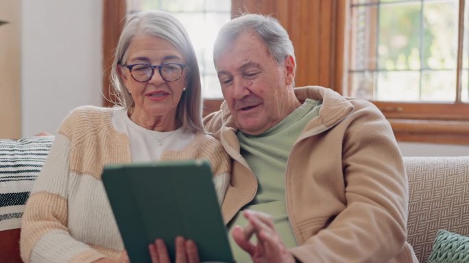 平板电脑，谈话和老夫妇在客厅沙发上的社交媒体网络。数字技术、纽带和退休老人在家里的手机应用或互联网上