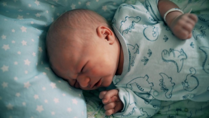 在妇产医院的婴儿床上，不舒服的男婴在哭泣
