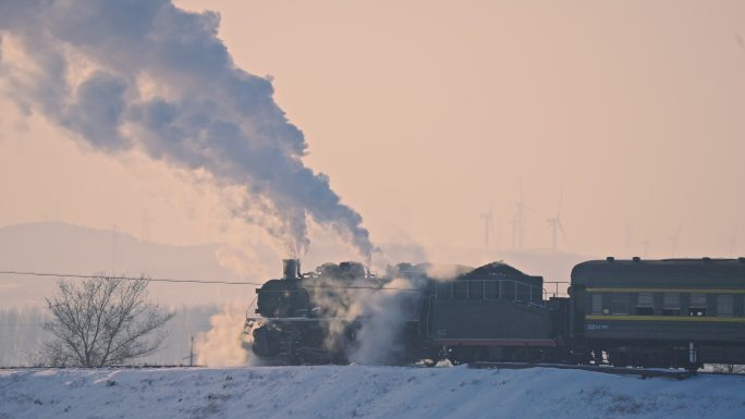 中国东北冬季白雪落日下的蒸汽机车老式火车