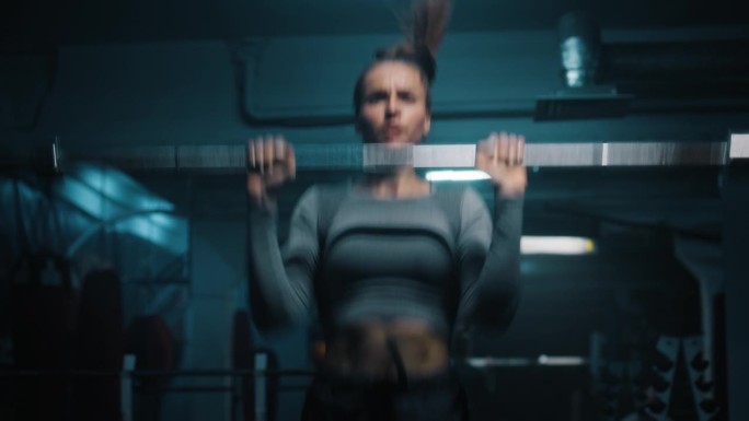 女运动员在健身房里举空杠铃做练习