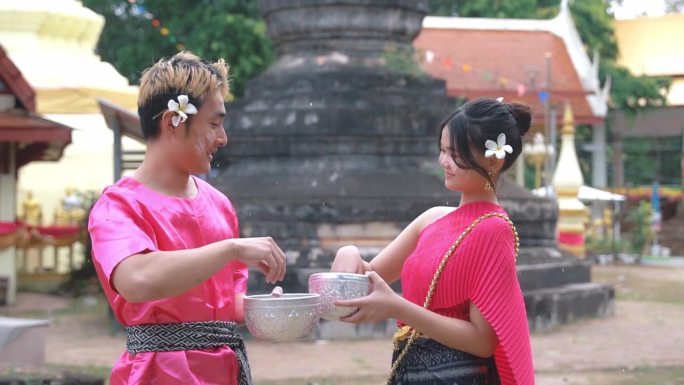 在泼水节期间，一对穿着传统泰国服装的夫妇在水里玩耍。