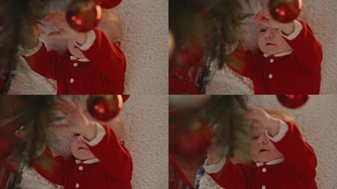 宝宝躺在家里的地毯上玩挂在圣诞树上的小玩意的高角度手持镜头