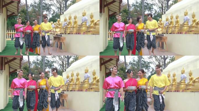 一群年轻人和夫妇在泼水节期间穿着传统的泰国泼水服装。