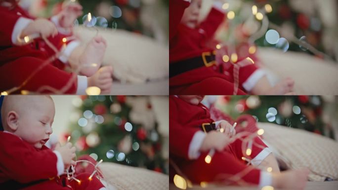 手持拍摄的男婴穿着圣诞老人服装在家里的沙发上玩圣诞灯