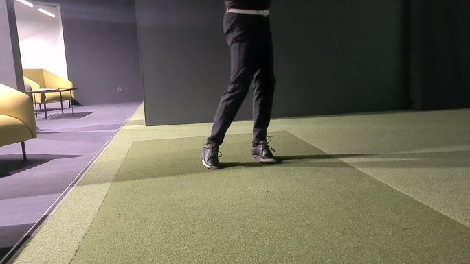 职业男子高尔夫球手在高尔夫模拟器室内打高尔夫球特写