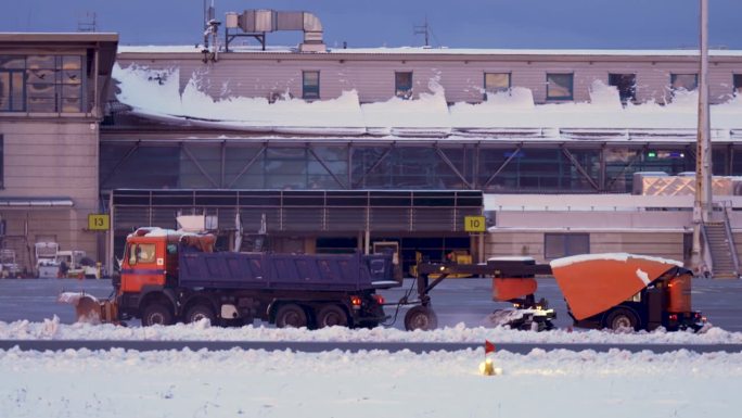 扫雪车在国际机场航站楼和跑道清理积雪