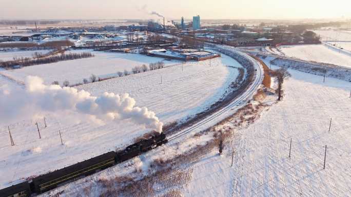 航拍中国东北冬季雪景中的蒸汽火车穿过村庄