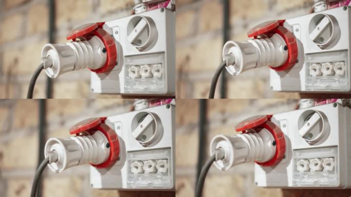 白色电源插座外墙上带插头，高压三相电源，用于五金工业，电源和电力的概念