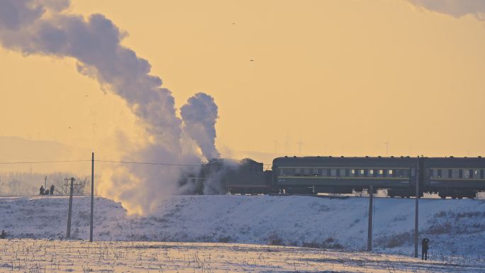 中国东北冬季白雪落日下的蒸汽机车老式火车