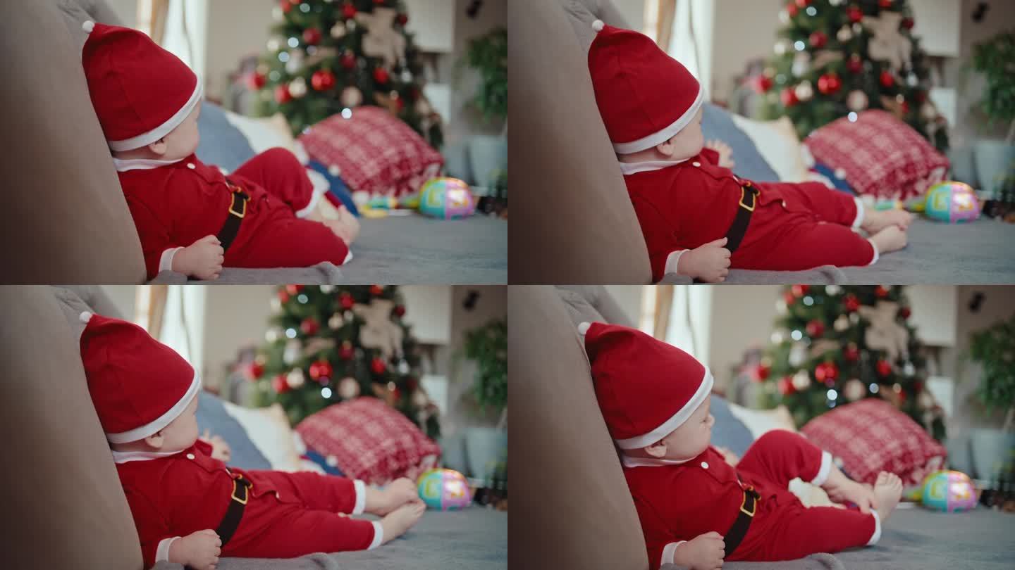 圣诞期间，可爱的小男孩穿着圣诞老人的服装倒在家里的沙发上