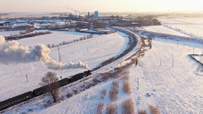 航拍中国东北冬季雪景中的蒸汽火车穿过村庄