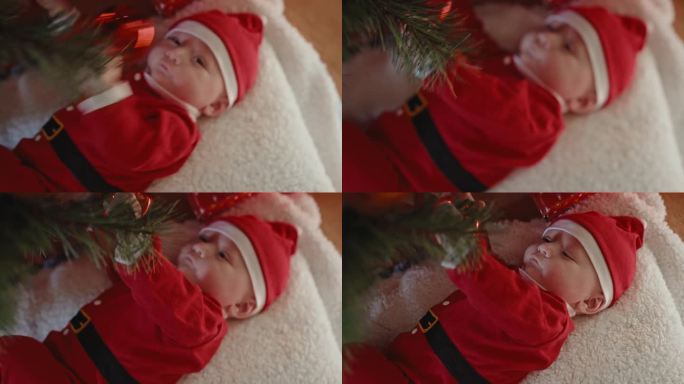 正上方的手持照片，可爱的小男孩在家里玩挂在圣诞树上的小玩意