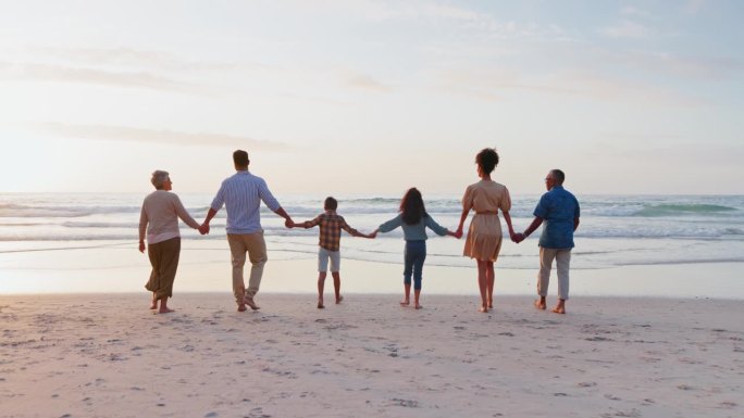 回来了，手牵着手和家人一起享受日落、海滩和有海洋、水和支持的假期。爷爷奶奶，爸爸妈妈带着孩子，孩子和