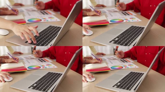 设计师团队使用笔记本电脑的慢动作手部特写。组合成的