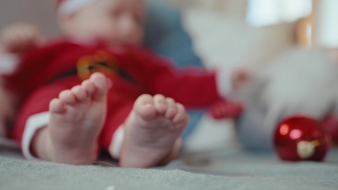 手持拍摄的宝宝在沙发上玩红色小玩意，重点是赤脚在家里