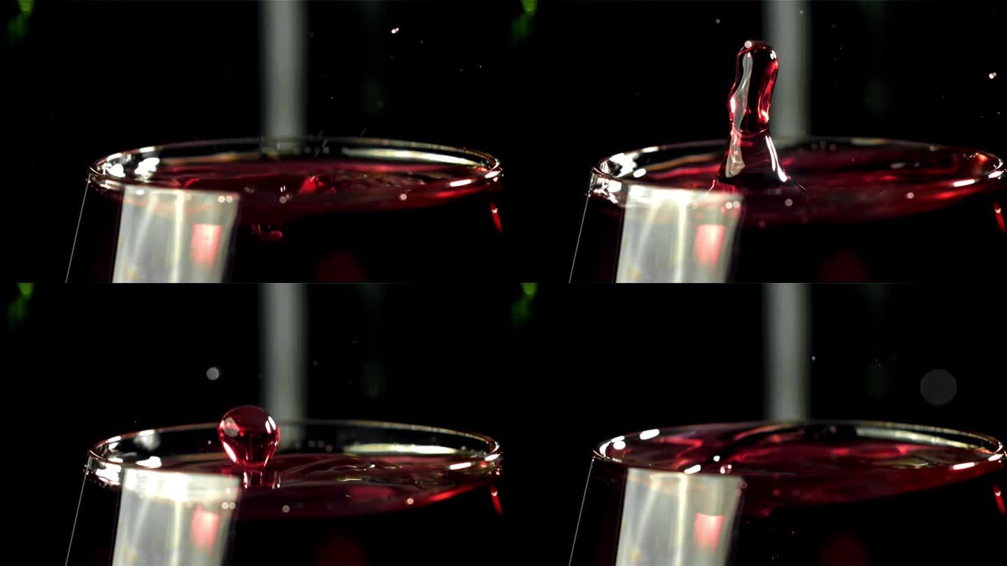 一滴水滴进了一杯酒。黑色背景。用高速摄像机拍摄，每秒1000帧。