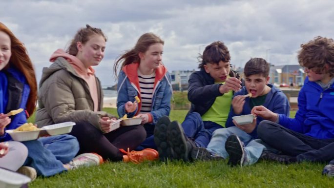青少年在海边分享薯条