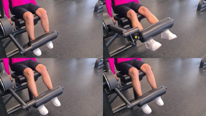 女性腿部在健身房的力量训练机上训练大腿股四头肌