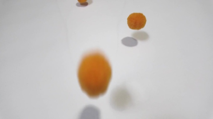 橙色的绒球落在白色的背景上。